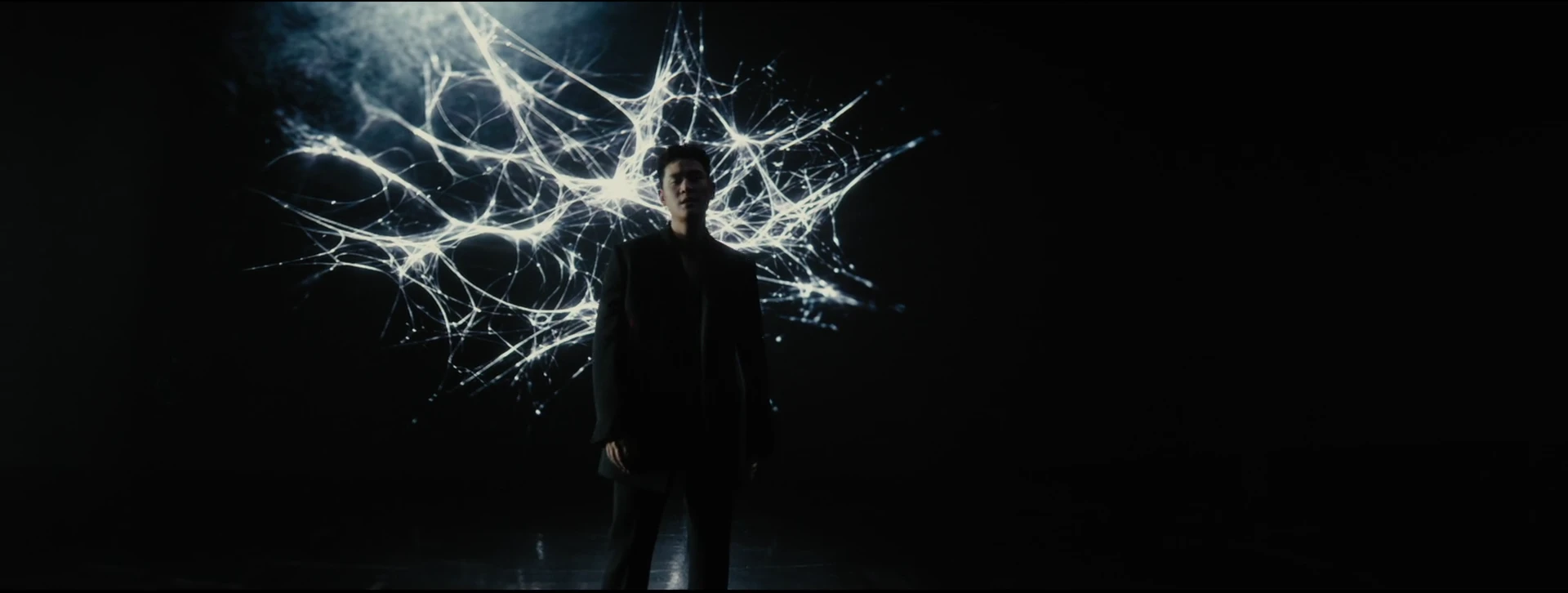 Eric Chou performs before an intricate branching sculpture of white light.