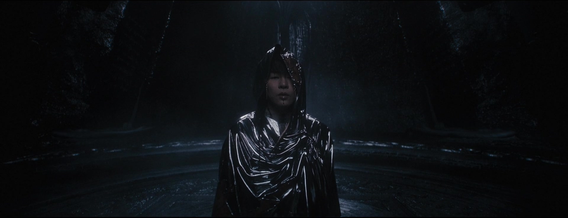 Tiger Hu faces the camera beneath a reflective silver hood in the dark chamber.