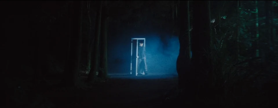 An illuminated doorway deep in the forest.