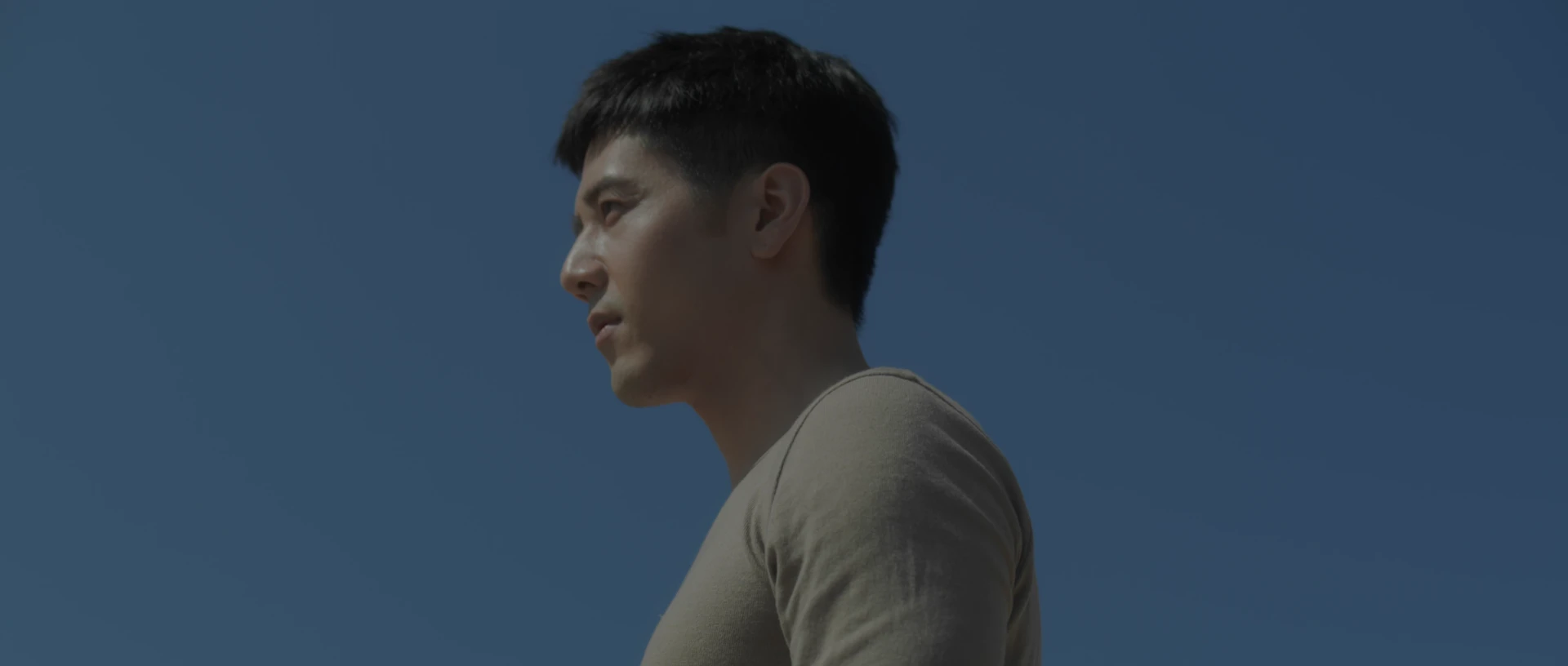 George Hu in a clear side portrait against an open blue sky.