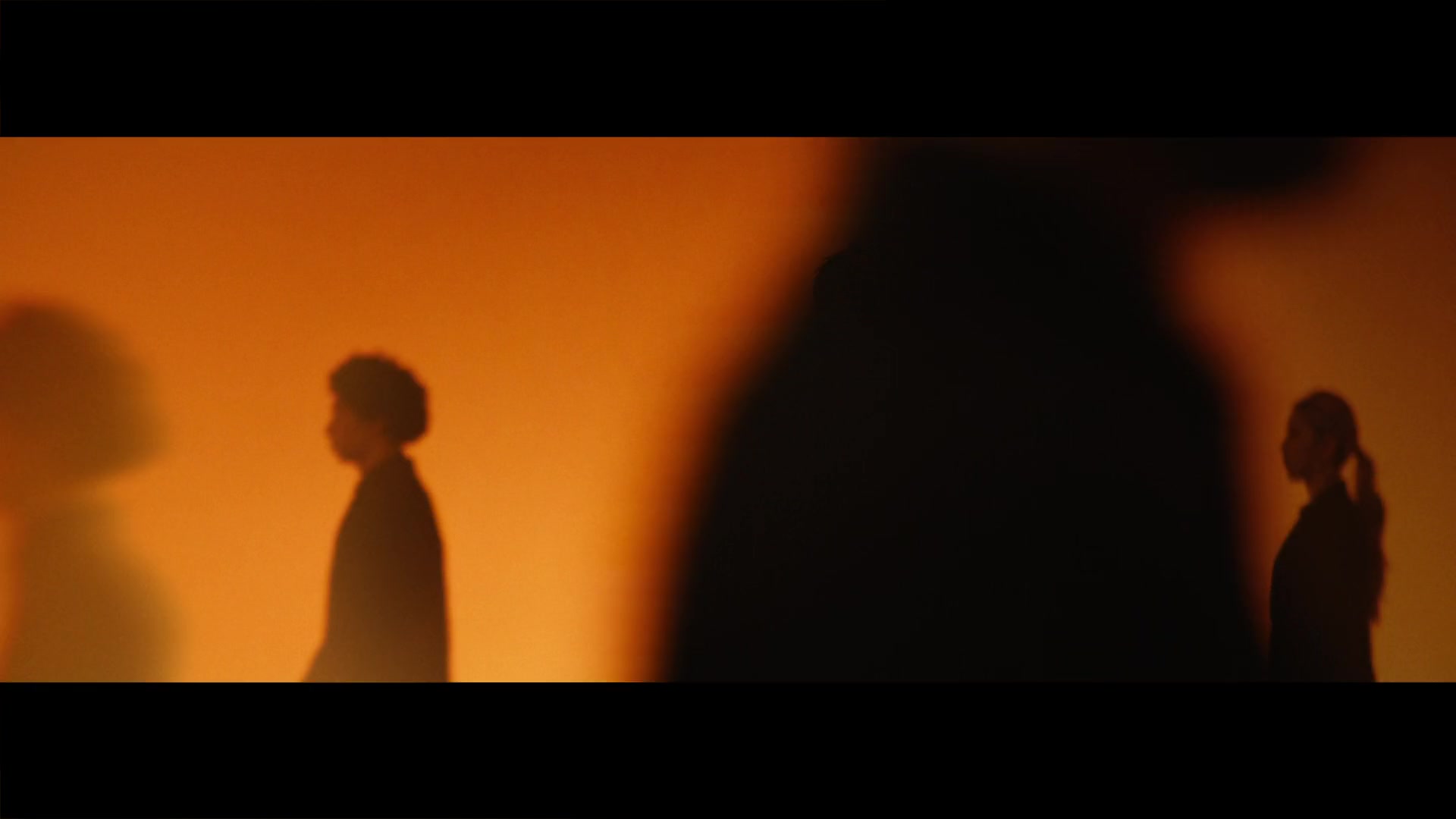 Eric Chou — Figures and shadows in an orange-lit room