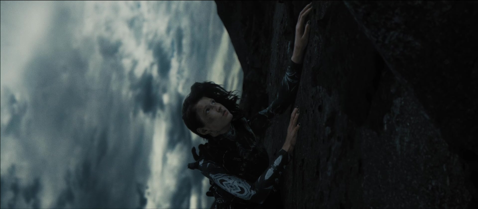 A tilted portrait beside a rock wall